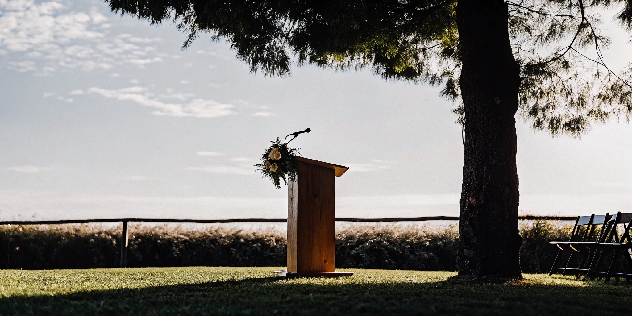 Wedding officiant's podium with microphone and flowers.