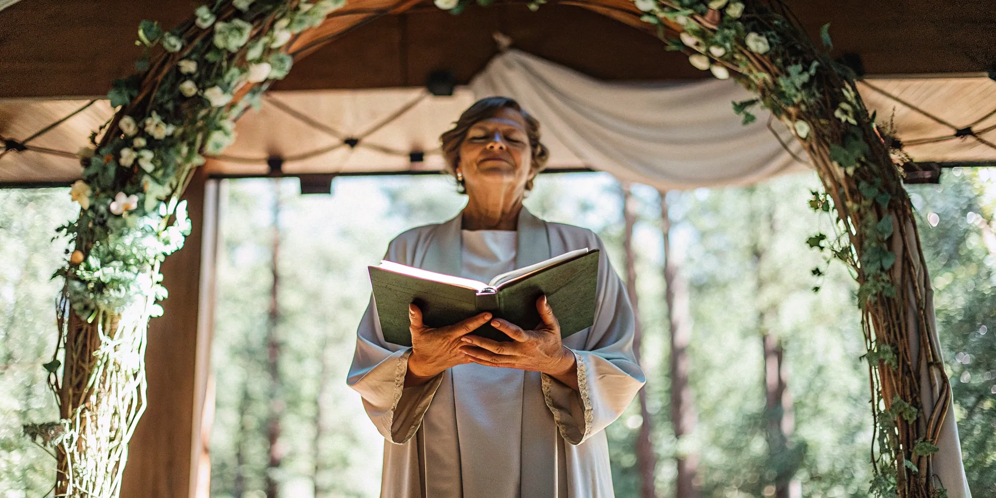 Ordained officiant prepares for wedding ceremony under floral arch.