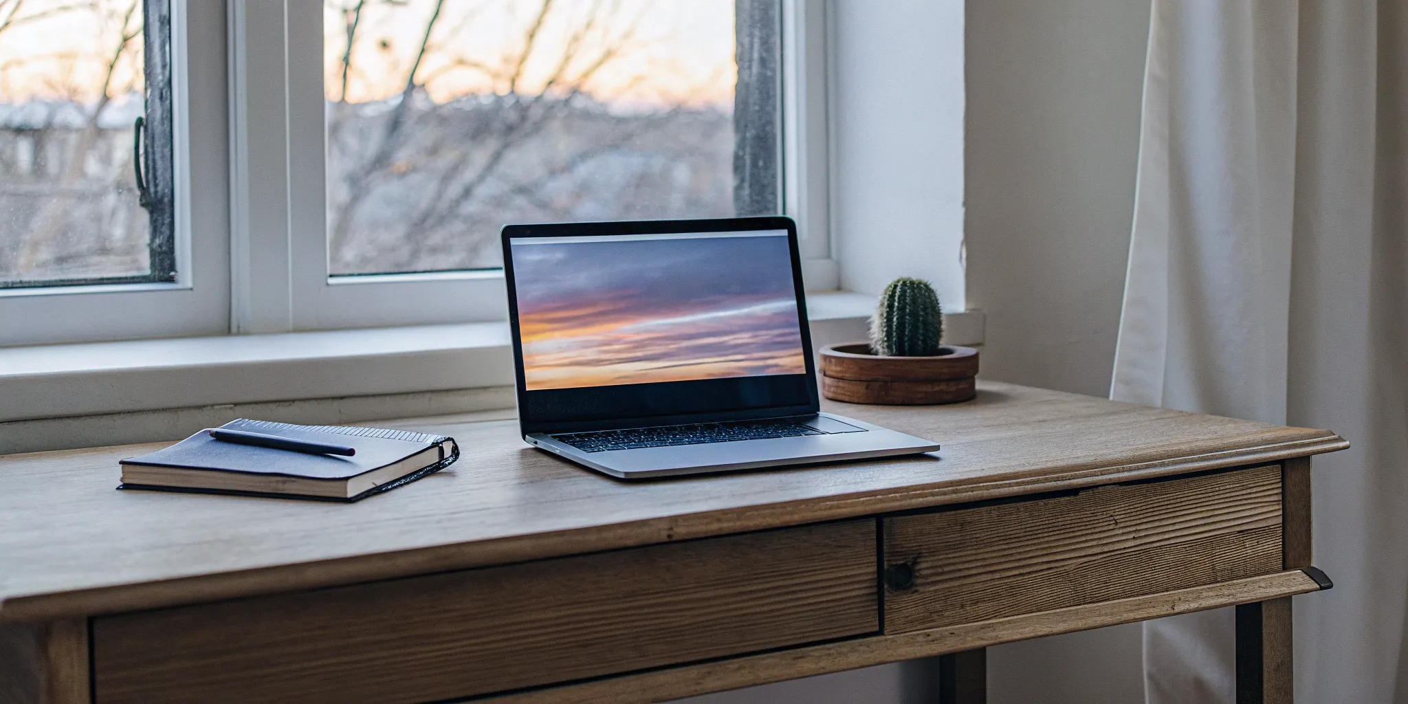 A desk with a laptop and notebook to get ordained online in Texas.